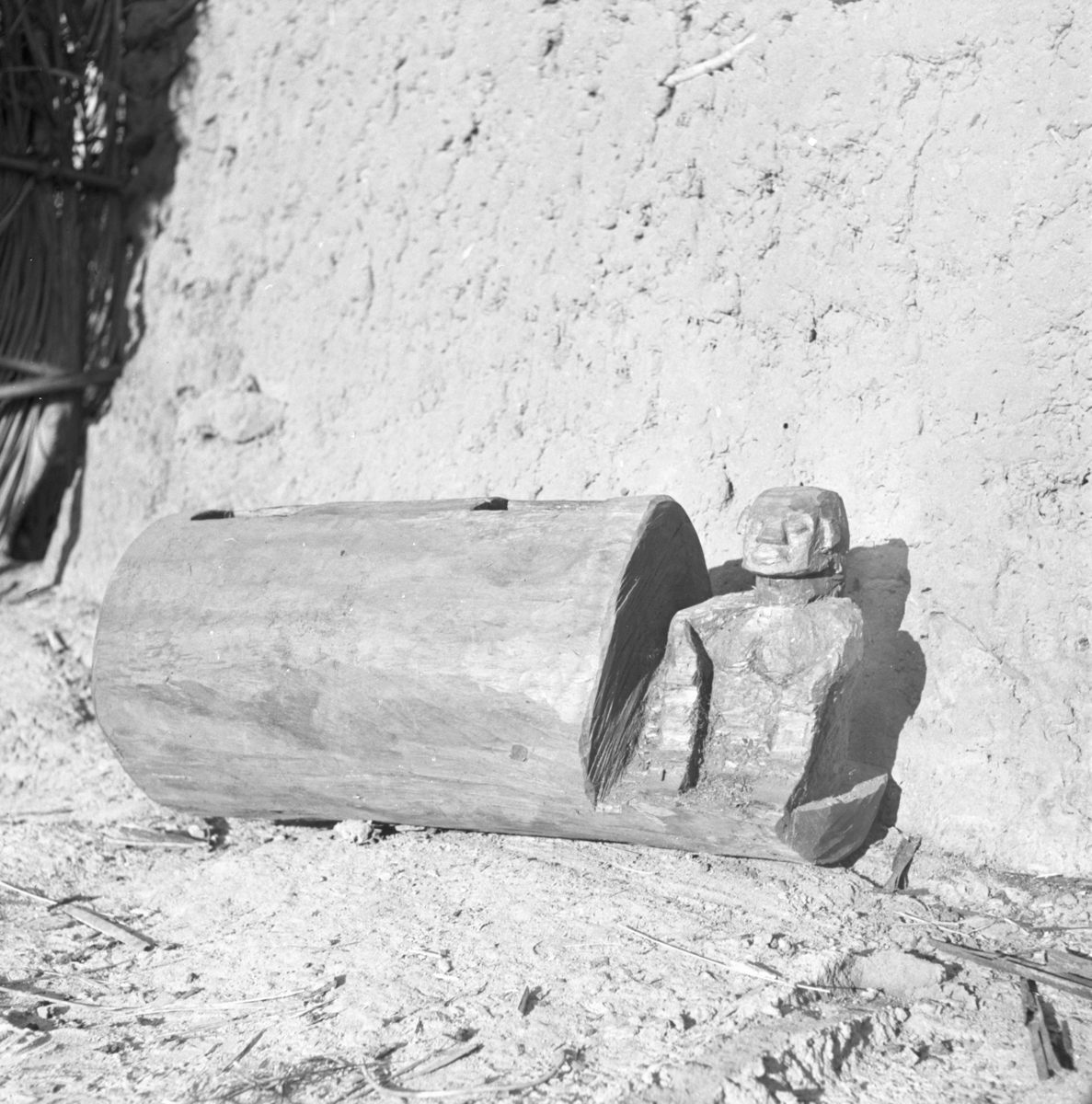 An Ikoro slit drum with a carved head and upper torso. Photograph by Gwilliam Iwan Jones, 1932-1939, Ohafia, Nigeria. Image source: Jones Collection.